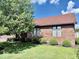 The brick home has several mulched planting beds with round shrubs beneath the windows at 3400 W Riggin Rd, Muncie, IN 47304