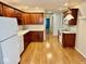 Well-lit kitchen with white appliances, laminate floor and dark cabinetry at 3400 W Riggin Rd, Muncie, IN 47304