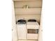 Convenient laundry closet features a stacked washer and dryer with functional shelving for storage at 3400 W Riggin Rd, Muncie, IN 47304