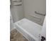 Clean white bathtub with a showerhead and grab bar for safety and accessibility at 5332 Fletcher Ave, Indianapolis, IN 46219