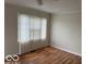 Inviting bedroom with wood floors, neutral walls, and a window with plenty of sunlight at 5332 Fletcher Ave, Indianapolis, IN 46219