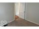 Bedroom featuring light colored walls and carpet, and view of hall with hardwood floors at 5332 Fletcher Ave, Indianapolis, IN 46219