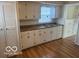 Classic kitchen features wood floors, ample counter space, white cabinets, and a view from the window at 5332 Fletcher Ave, Indianapolis, IN 46219