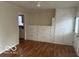 Spacious room with wood floors, built-in cabinets, and an adjoining kitchen for versatile use at 5332 Fletcher Ave, Indianapolis, IN 46219