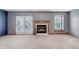 Cozy living room with a fireplace, sliding glass doors to the patio, and neutral carpeting at 5370 Bay Harbor Dr, Indianapolis, IN 46254