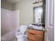 Standard bathroom with a shower-tub combo, toilet, vanity with mirror, and dark countertops at 5548 Glen Canyon Dr, Indianapolis, IN 46237