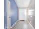 Hallway with neutral and blue walls, showing tile flooring leading to a white front door with sidelight window at 5548 Glen Canyon Dr, Indianapolis, IN 46237