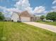 Attractive home with an attached two-car garage, set on a well-maintained lawn with lush green grass at 5548 Glen Canyon Dr, Indianapolis, IN 46237