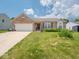Inviting brick home with an attached two-car garage and a lush front lawn adorned with vibrant flowerbeds at 5548 Glen Canyon Dr, Indianapolis, IN 46237