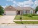 Charming brick home featuring an attached garage and a well-maintained front lawn with flower beds at 5548 Glen Canyon Dr, Indianapolis, IN 46237