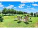 Manicured backyard with plush green grass, landscaping, patio seating and open space at 6383 Enclave Blvd, Greenwood, IN 46143