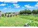 Green backyard with landscaping, seating and mature trees at 6383 Enclave Blvd, Greenwood, IN 46143