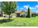 Beautiful one-story home with a manicured lawn and lush green tree in a serene neighborhood at 6383 Enclave Blvd, Greenwood, IN 46143