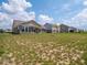 Large, grassy backyard with partial bare spots and a view of several houses at 7241 Glen Park Ln, Indianapolis, IN 46259