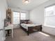 Sunlit bedroom with carpet, two windows, and a dark wood bed frame at 7241 Glen Park Ln, Indianapolis, IN 46259