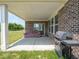 Covered patio featuring brick pillars, a comfortable sofa, and a grill, perfect for outdoor entertaining at 7241 Glen Park Ln, Indianapolis, IN 46259