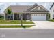 Close-up of charming brick home showcasing a two-car garage, covered porch, and manicured lawn at 7241 Glen Park Ln, Indianapolis, IN 46259