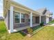 Covered front porch framed by elegant columns with brick facade and garden bed at 7241 Glen Park Ln, Indianapolis, IN 46259