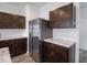 A modern kitchen with stainless steel refrigerator and marble countertop and dark wood cabinets at 7241 Glen Park Ln, Indianapolis, IN 46259