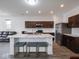 Modern kitchen features a center island with marble countertops, stainless steel appliances, and dark wood cabinets at 7241 Glen Park Ln, Indianapolis, IN 46259