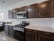 The kitchen is modern with a stainless steel gas stove, microwave, white backsplash, marble countertops, and dark wood cabinets at 7241 Glen Park Ln, Indianapolis, IN 46259