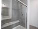 Glass-enclosed shower with gray tile surround and a built-in seat at 7241 Glen Park Ln, Indianapolis, IN 46259