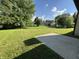 Expansive backyard with a well-maintained lawn, mature trees, and a concrete patio at 7313 Shanna Cir, Indianapolis, IN 46236