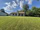 Expansive backyard with green lawn and a view of the home's exterior; ideal for gardening and entertainment at 7313 Shanna Cir, Indianapolis, IN 46236