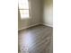Bedroom with a window providing natural light and wood-look vinyl plank flooring at 7313 Shanna Cir, Indianapolis, IN 46236