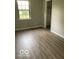 A bedroom featuring newly installed laminate flooring and a window providing natural light at 7313 Shanna Cir, Indianapolis, IN 46236