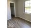Bedroom featuring a window, grey walls and modern vinyl plank flooring at 7313 Shanna Cir, Indianapolis, IN 46236