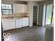 Bright kitchen with white cabinets, a window, and modern grey vinyl plank flooring at 7313 Shanna Cir, Indianapolis, IN 46236
