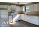 Spacious kitchen featuring white appliances and cabinets, complete with vinyl plank flooring at 7313 Shanna Cir, Indianapolis, IN 46236