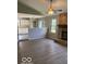 Open floor plan living room with stone fireplace, hardwood floors, and kitchen view at 7313 Shanna Cir, Indianapolis, IN 46236
