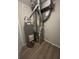 Utility room featuring a water heater, HVAC system, and wood-look flooring at 7313 Shanna Cir, Indianapolis, IN 46236