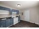 Functional kitchen featuring blue cabinets, white appliances, and wood-look flooring at 7424 North Dr, Lawrence, IN 46226