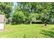 Extensive backyard with verdant lawn, mature trees, and a shed, offering plenty of space at 7643 S Delaware St, Indianapolis, IN 46227