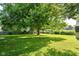 Lush backyard with mature trees, grassy lawn, and a shed, creating a serene outdoor retreat at 7643 S Delaware St, Indianapolis, IN 46227