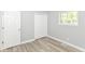 Bedroom with closet featuring gray walls, light wood-look flooring, and a bright window at 7643 S Delaware St, Indianapolis, IN 46227