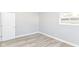 Simple bedroom with light wood flooring, gray walls, a window, and white door at 7643 S Delaware St, Indianapolis, IN 46227