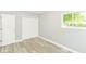 Bright bedroom featuring gray walls, light wood-look flooring, and a window for natural light at 7643 S Delaware St, Indianapolis, IN 46227