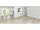 Bright living room featuring modern vinyl plank flooring and a view to the kitchen with white cabinets at 7643 S Delaware St, Indianapolis, IN 46227