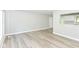 Bright living room featuring fresh gray paint and modern vinyl plank flooring with a kitchen view at 7643 S Delaware St, Indianapolis, IN 46227