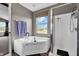 Bright bathroom features a soaking tub, shower, and a window with a neighborhood view at 793 Penny Ln, Pittsboro, IN 46167