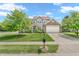 Traditional two-story home with tan siding, brick accents, manicured lawn, and mature trees at 793 Penny Ln, Pittsboro, IN 46167