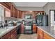 Kitchen featuring dark wood cabinets, black appliances, and wood floors at 793 Penny Ln, Pittsboro, IN 46167