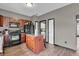Kitchen featuring dark wood cabinets, black appliances, wood floors and a kitchen island at 793 Penny Ln, Pittsboro, IN 46167