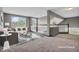 A virtual staging of the living room with two large windows, sofa, chair, metal coffee tables and a soft rug at 793 Penny Ln, Pittsboro, IN 46167