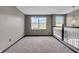 Carpeted loft space features neutral paint, chandelier, and a large double window offering natural light at 793 Penny Ln, Pittsboro, IN 46167