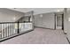 View of carpeted loft area with neutral paint, chandelier, and black and white banister at 793 Penny Ln, Pittsboro, IN 46167